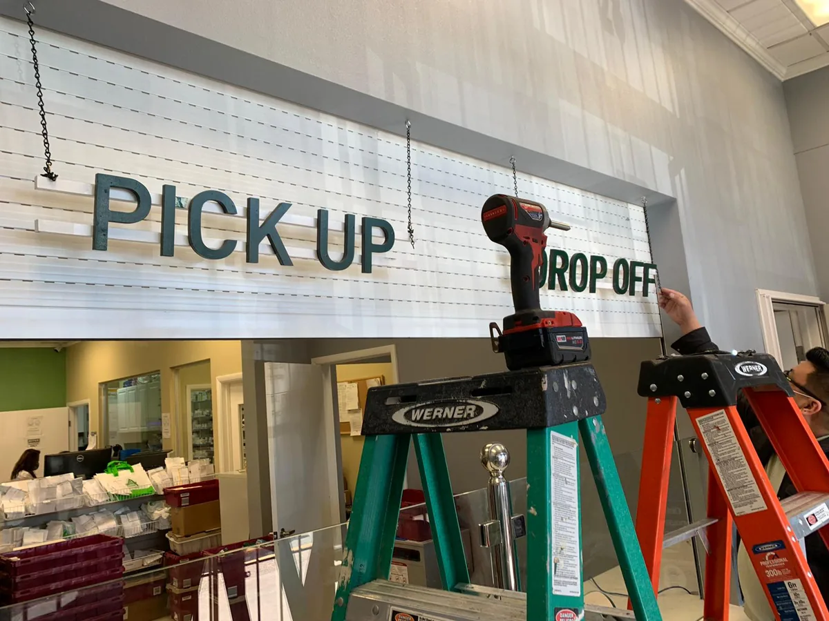 Pickup and drop-off counter with ladders and a cordless drill on the work platform
